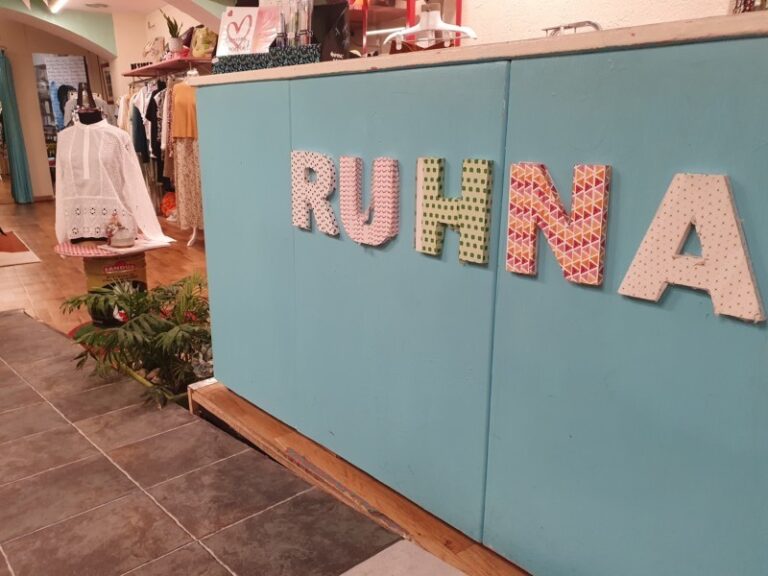 Tienda de ropa con letrero "RUHNA" decorativo.
